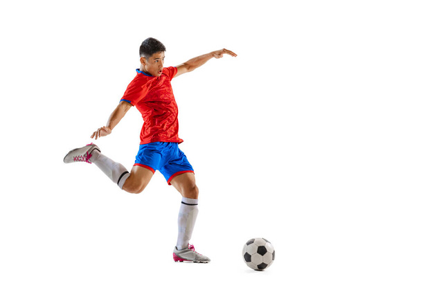 Portrait of young man, professional football player in motion, training, dribbling ball isolated over white studio background. Concept of sport, team game, action, motion. Copy space for ad, poster - Foto, Imagem