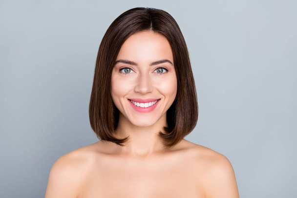 Portrait of beautiful smiling naked shoulders female smiling with perfect white new veneers isolated on grey color background. - Foto, afbeelding
