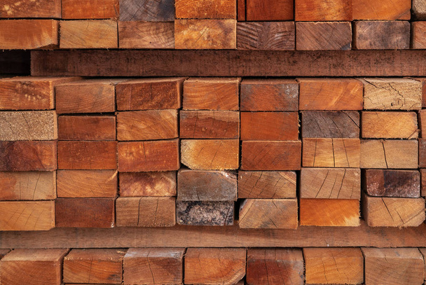 Stack of lumber in sawmill. Wood materail for construction industry. Pile of timber storage in warehouse. Lumber industrial. Closeup wooden boards in sawmill warehouse. Wood production industry. - Zdjęcie, obraz