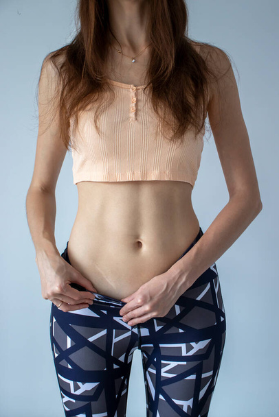 Slim Woman shows the scar from appendicitis on her stomach. - Фото, изображение