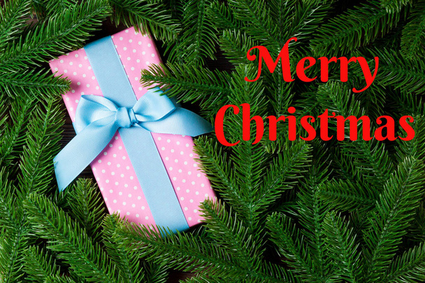 Merry Christmas text. Top view of Christmas gift box on fir tree background. Time for holiday concept with copy space. - Foto, immagini