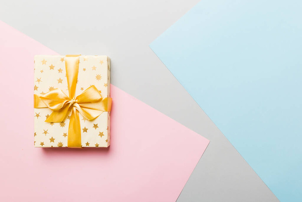 holiday paper present tied yellow ribbon bow top view with copy space. Flat lay holiday background. Birthday or christmas present. Christmas gift box concept with copy space. - Foto, Imagen