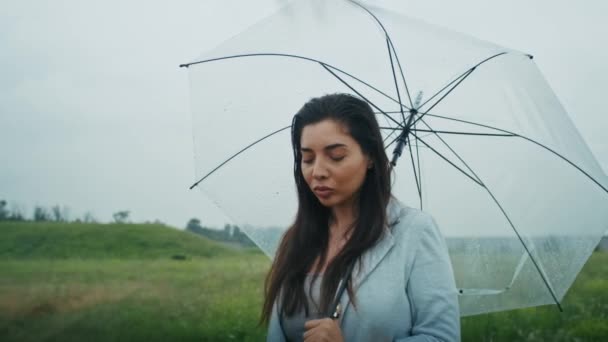 грустная армянка идет под дождем с зонтиком. ей нравится эта погода - Кадры, видео