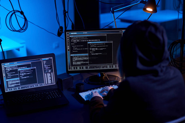 cybercrime, hacking and technology concept - female hacker in dark room writing code or using computer virus program for cyber attack - Φωτογραφία, εικόνα