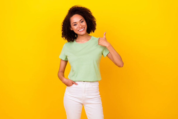 Photo of funny brunette curly lady thumb up wear t-shirt pants isolated on bright yellow color background. - Foto, immagini