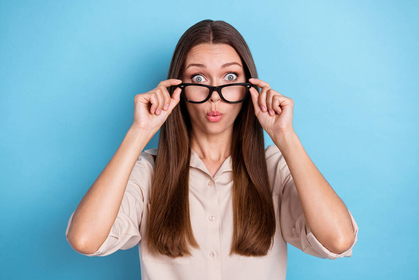 Photo of adorable nice sweet girl with straight hair wear beige shirt impressed discount touch glasses isolated on blue color background. - 写真・画像