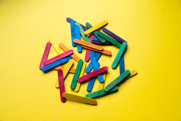 colored sticks on yellow background - Photo, Image