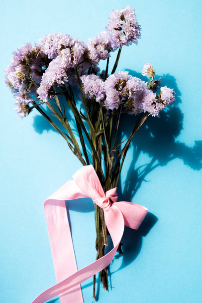 bouquet of dried flowers on a blue background, vertical frame - Photo, image