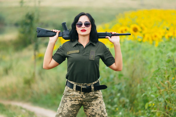 Στρατιώτης με στρατιωτική στολή. Ένα κορίτσι με στρατιωτική στολή με όπλο.. - Φωτογραφία, εικόνα