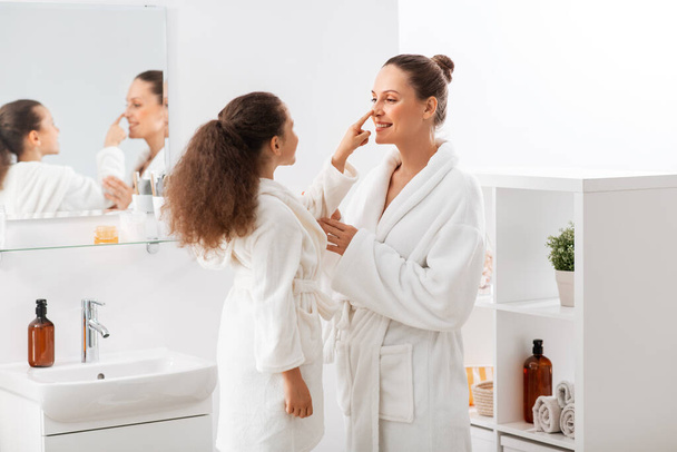 beauty, hygiene, morning and people concept - happy smiling mother and daughter having fun in at bathroom - Fotoğraf, Görsel