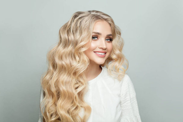 Retrato de mulher atraente com cabelo ondulado perfeito saudável longo contra fundo branco - Foto, Imagem