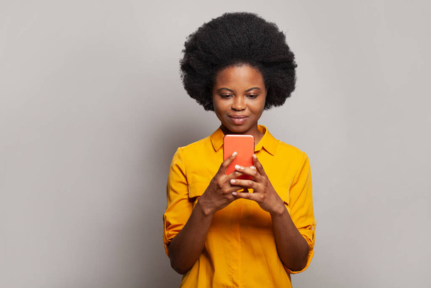 Veselý přátelsky vypadající žena zprávy, procházení internetu, pomocí smartphone a nakupování na bílém pozadí - Fotografie, Obrázek