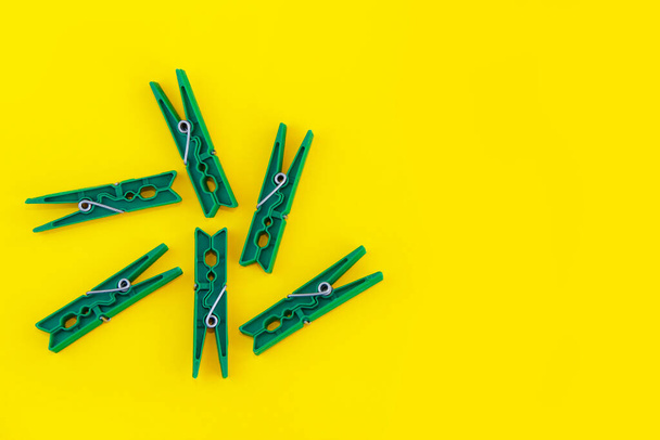 plastic clothespins for fastening laundry, on a yellow background - Fotoğraf, Görsel