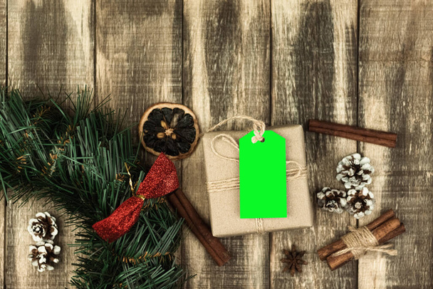 Метка на коробке с подарком, привязанная веревкой. Бумажная посылка, обернутая ценником на деревянном фоне. Ключ Chrome. копировальное пространство - Фото, изображение