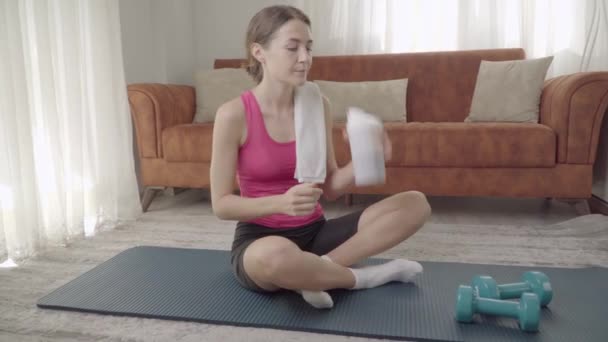 Kobieta potrząsa shakerem po ćwiczeniach domowych i pije białko. Wysokiej jakości materiał 4k - Materiał filmowy, wideo