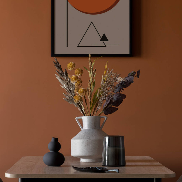 Close-up on elegant decorations on wooden dining table under art on orange wall - Fotó, kép