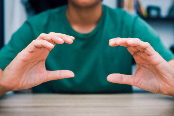 Teachers teach deaf students to learn sign language, symbols, characteristics of supporting both hands. on the wooden table in the room online learning at home - Photo, Image