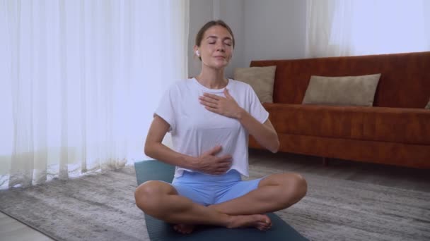 Μια γυναίκα κάνει την πρακτική της προσεκτικής αναπνοής στο σπίτι, διαλογισμό με την αναπνοή. Υψηλής ποιότητας 4k πλάνα - Πλάνα, βίντεο