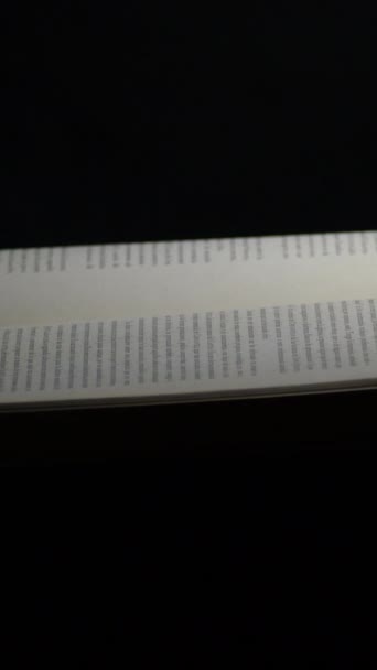 Páginas de livro aberto com fundo preto, rotação. 4K Vertical - Filmagem, Vídeo