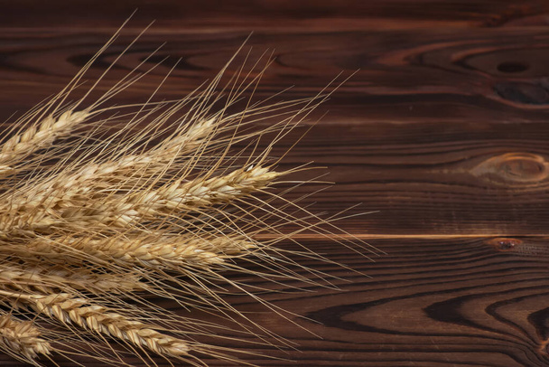 Orejas de trigo en la mesa de madera. Hoja de trigo sobre fondo de madera. Concepto de cosecha. - Foto, imagen