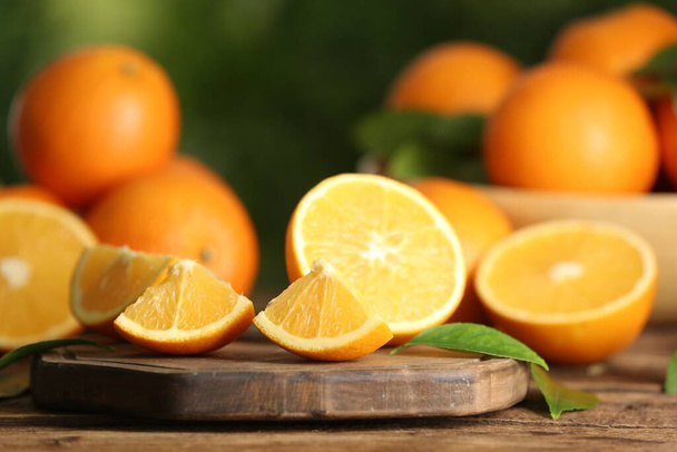 Fresh ripe oranges on wooden table against blurred background. Space for text - Foto, Imagen