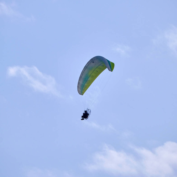 Италия; Сицилия, человек, летящий на параплане с двигателем  - Фото, изображение