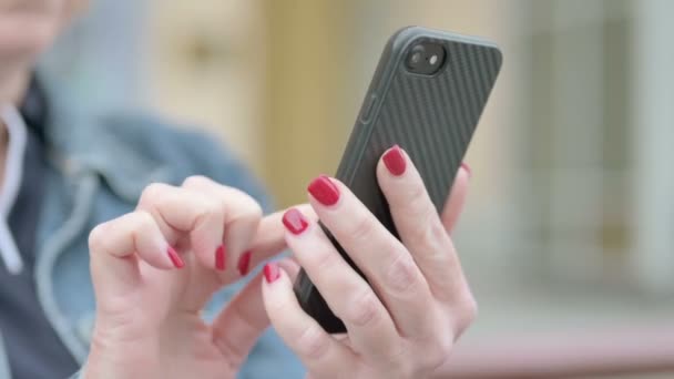 Крупним планом жінка рука за допомогою смартфона на відкритому повітрі
 - Кадри, відео