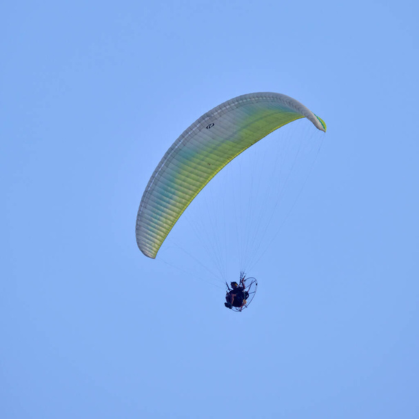 Italy; Sicily, man flying on a powered paraglider  - 写真・画像