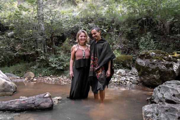 A young couple is smiling posing barefoot in the river. Concept of enjoying the nature - Foto, Bild