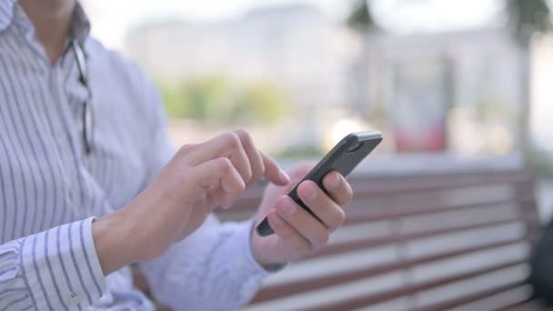 Крупним планом дорослий чоловік використовує смартфон на відкритому повітрі
 - Кадри, відео
