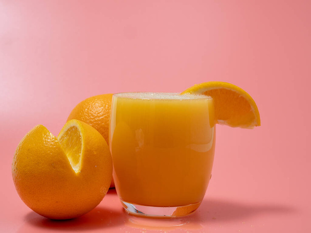 Orange and orange slice. Orange Juice Splashing. Orange on a pink background. Orange close up. - Fotografie, Obrázek