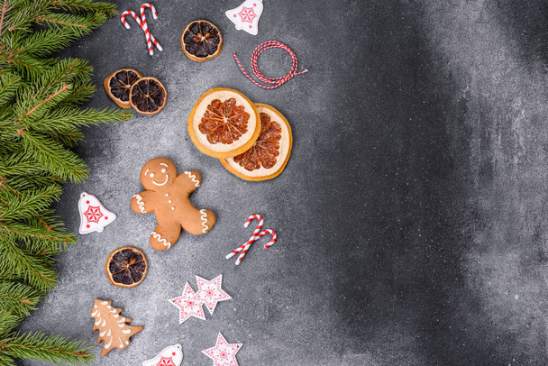 Gingerbread, Christmas tree decorations, dried citrus fruits on a gray concrete background to prepare a festive Christmas table - Foto, Imagen