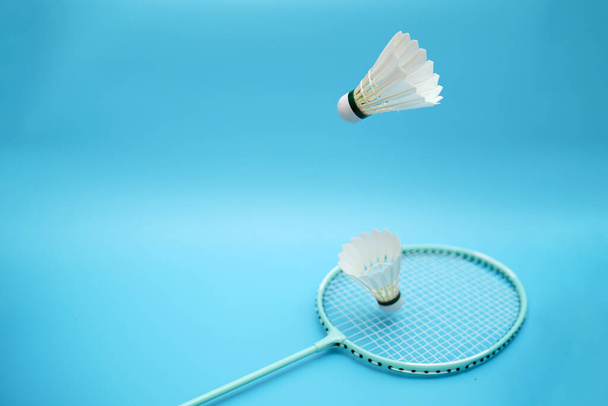 Two badminton shuttlecock and badminton racket on blue background - Foto, Imagem