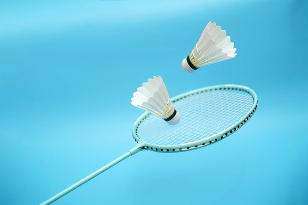 Badminton shuttlecocks and badminton racket on blue background - Photo, image