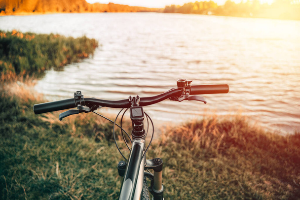 Mountain bike on a lake shore. Summer sunset adventures in the countryside. Using a bicycle in rural area. - Foto, Bild