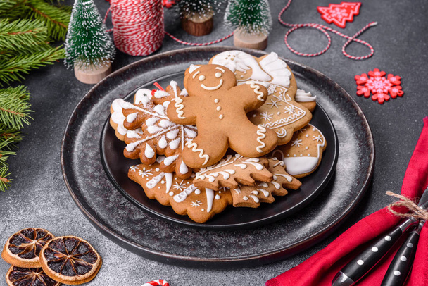 Gingerbread, Christmas tree decorations, dried citrus fruits on a gray concrete background to prepare a festive Christmas table - Foto, imagen