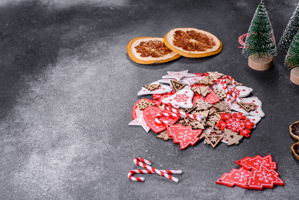 Gingerbread, Christmas tree decorations, dried citrus fruits on a gray concrete background to prepare a festive Christmas table - 写真・画像