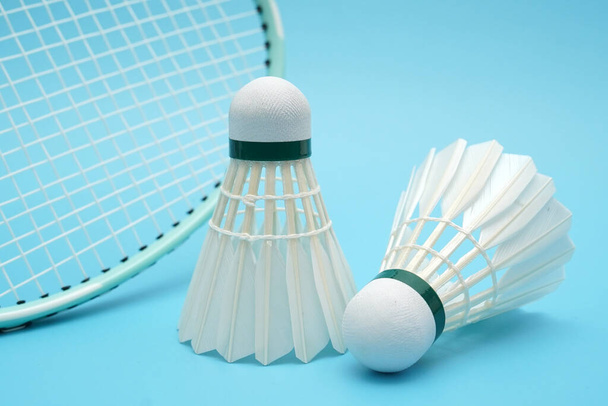 Badminton shuttlecock and badminton racket on blue background - Photo, image