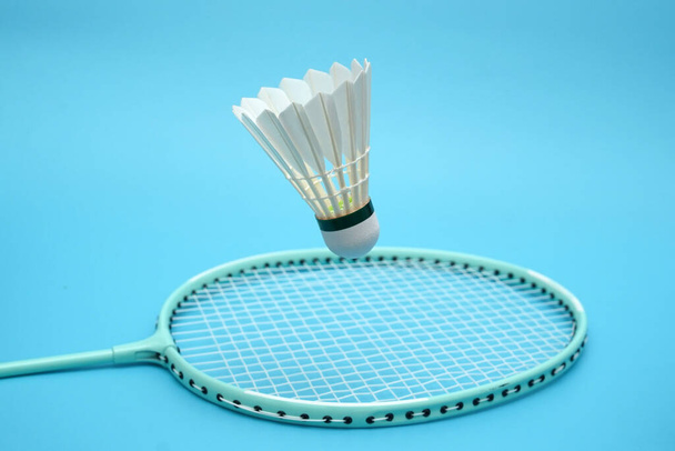 Badminton shuttlecock and badminton racket on blue background - Foto, afbeelding