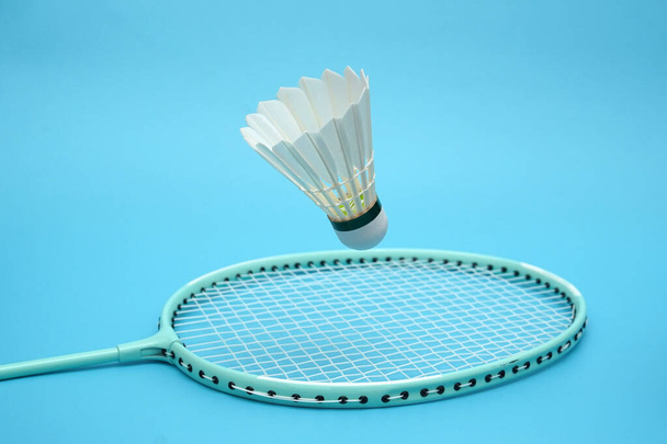 Badminton shuttlecock and badminton racket on blue background - Fotografie, Obrázek