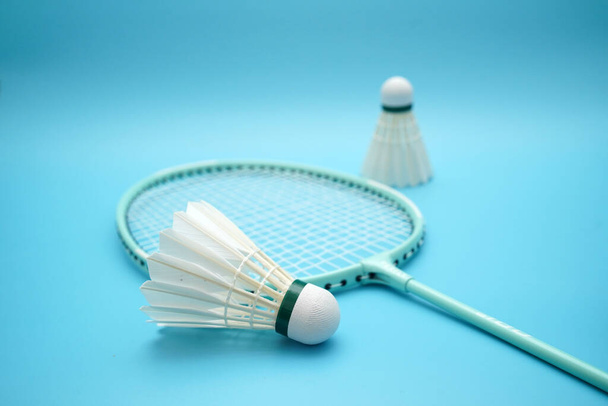 Badminton shuttlecock and badminton racket on blue background - Photo, Image