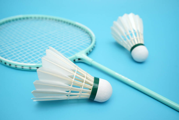 Badminton shuttlecock and badminton racket on blue background - Foto, Imagen