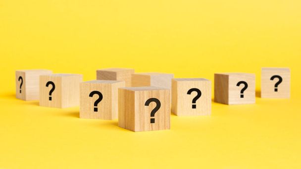 вид спереду на багато дерев'яних кубиків з позначками питань. багато питань виникає концепція. біда і плутанина. жовтий фон - Фото, зображення