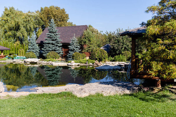 Деревянный газон для отдыха на свежем воздухе. Место в природе с деревянным домом - Фото, изображение