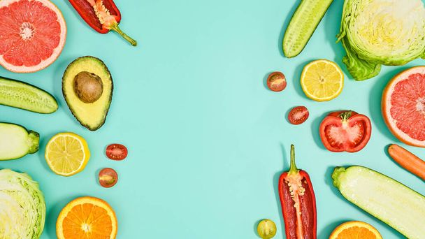 Copy space background with sliced fresh fruits and vegetables on cyan theme. Flat lay HEalthy lifestyle - Photo, Image