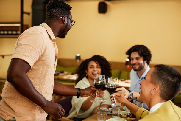 Φίλοι τοστ με κρασί στο οινοποιείο κατά τη διάρκεια ενός πάρτι. - Φωτογραφία, εικόνα