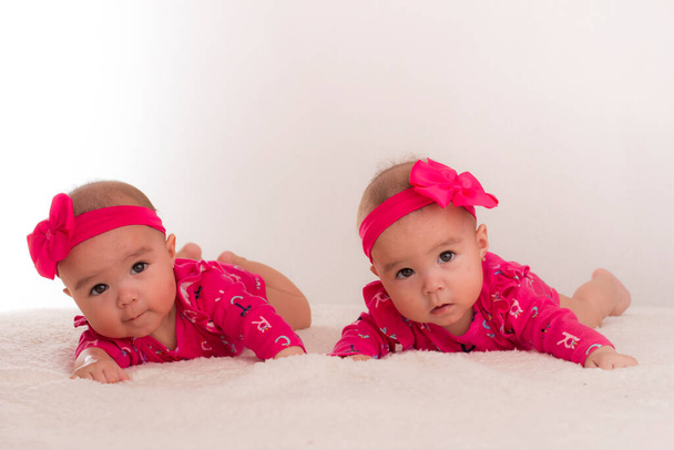 baby twins lying in bed with bow on head - Foto, Imagem