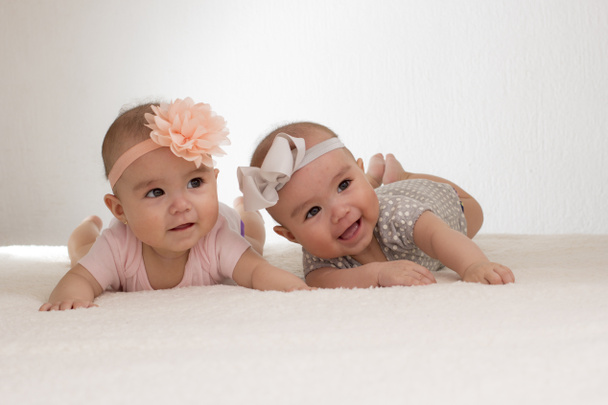 baby twins lying in bed with bow on head - Photo, image