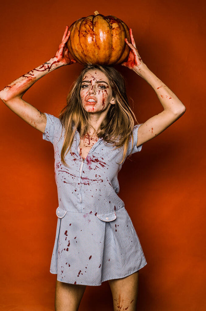 Girl with pumpkin. Full of blood. Bloody make up. Animal hunger - 写真・画像
