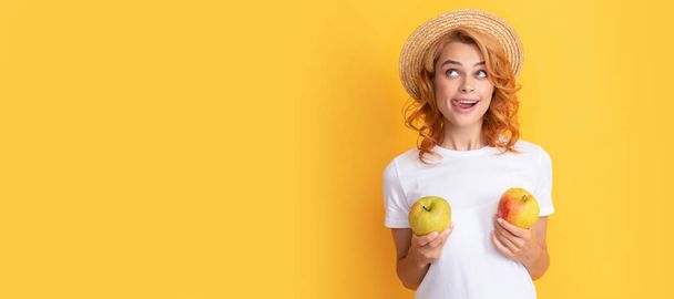 Summer girl hold apple. cheerful redhead woman in straw hat hold apple licking lips, dietary. Woman isolated face portrait, banner with mock up copy space - Zdjęcie, obraz